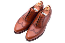 Brązowe eleganckie obuwie skórzane z ażurkami i dekoracyjnymi zdobieniami koloru jasno brązowego typu brogues z gumową podeszwą. Szyte metodą ramową.