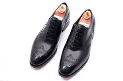Eleganckie obuwie koloru czarnego typu brogues ze skórzaną podeszwą. Szyte metodą ramową.