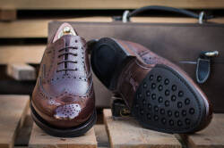 Eleganckie obuwie koloru ciemno brązowego typu brogues z gumową podeszwą. Szyte metodą ramową.