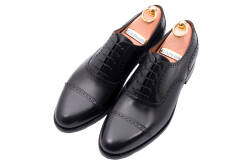 Eleganckie skórzane obuwie z ażurkami i dekoracyjnymi zdobieniami koloru czarnego typu brogues ze skórzaną podeszwą. Szyte metodą ramową.