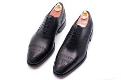 Eleganckie obuwie koloru czarnego typu brogues z skórzaną podeszwą. Szyte metodą ramową.