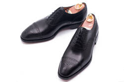 Eleganckie obuwie koloru czarnego typu brogues ze skórzaną podeszwą. Szyte metodą ramową.