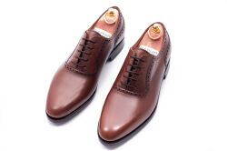 Eleganckie obuwie koloru brązowego typu brogues z skórzaną podeszwą. Szyte metodą ramową.